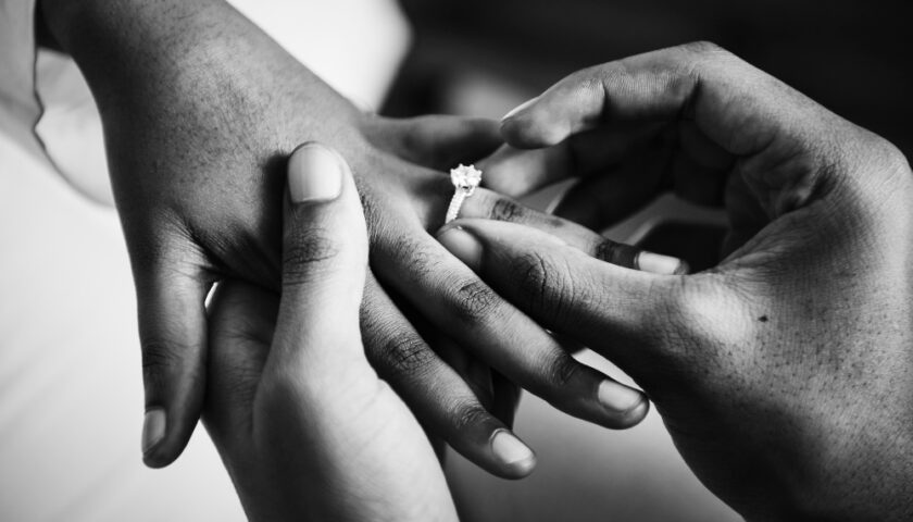 photo en noir et blanc d'un homme mettant une bague au doigt d'un homme